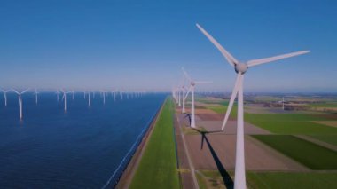 Hollanda Flevoland 'daki yel değirmeni türbinleri Hollanda' daki ijsselmeer gölünün yanındaki yeşil enerji rüzgar türbinleri.