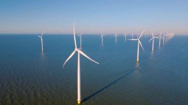 Hollanda Flevoland 'daki yel değirmeni türbinleri Hollanda' daki ijsselmeer gölünün yanındaki yeşil enerji rüzgar türbinleri.