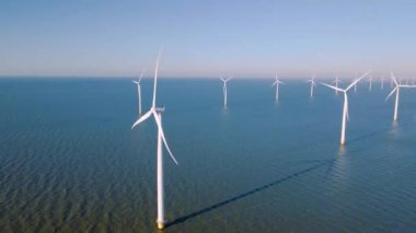 Hollanda Flevoland 'daki yel değirmeni türbinleri Hollanda' daki ijsselmeer gölünün yanındaki yeşil enerji rüzgar türbinleri.