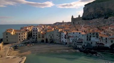 Cefalu Sicilya, Cefalu Sicilya sahilinde gün batımı, Sicilya 'da tatil yapan orta yaşlı erkek ve kadın.