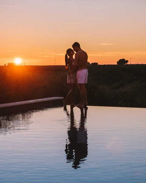 Pár nyaralni luxus üdülőhelyen Szicíliában naplementekor a végtelen medence Szicília Olaszország — Stock Fotó