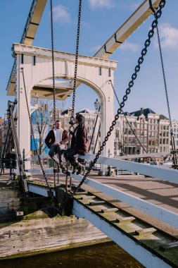 Amsterdam tarihi merkezine şehir gezisine çıkan iki erkek ve kadın Amsterdam Hollanda