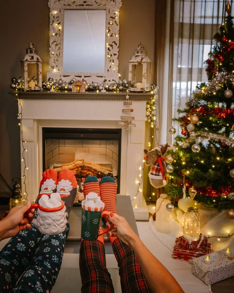 Choinka i kominek, skarpetki świąteczne i gorące filiżanki czekolady przy kominku podczas świąt Bożego Narodzenia — Zdjęcie stockowe