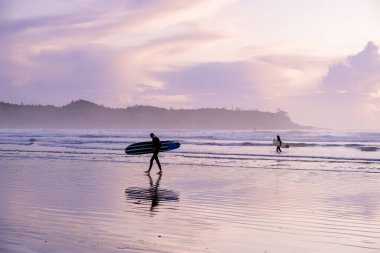 Tofino Vancouver Adası Pasifik kıyıları, günbatımında sörfçüler plajda, siluet Kanada Vancouver Adası Tofino Sörfçüleri. 