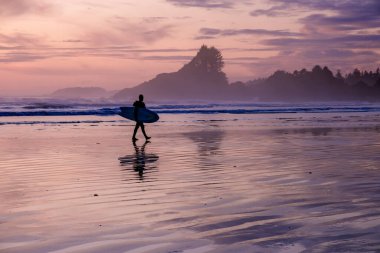 Tofino Vancouver Adası Pasifik kıyıları, günbatımında sörfçüler plajda, siluet Kanada Vancouver Adası Tofino Sörfçüleri. 