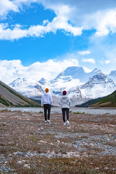 Pár középkorú férfiak és nők túrázás a kanadai Sziklás-hegység közelében Alberta Banff nemzeti park havas hegyek — Stock Fotó