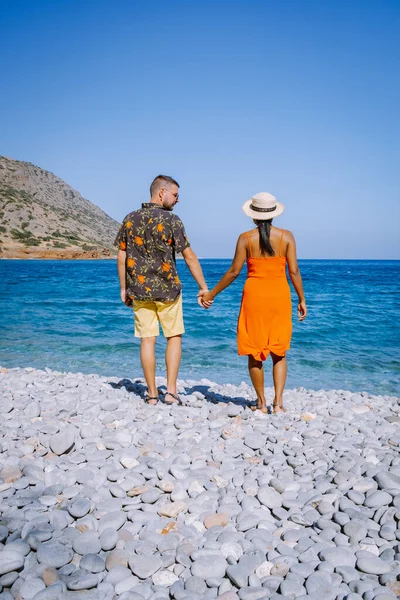 Pareja de hombres y mujeres en la playa de Plaka Creta con vistas al océano azul de Creta Grecia —  Fotos de Stock