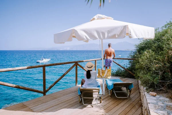 Paar in ligstoelen op een tropisch strand van Kreta Griekenland — Stockfoto