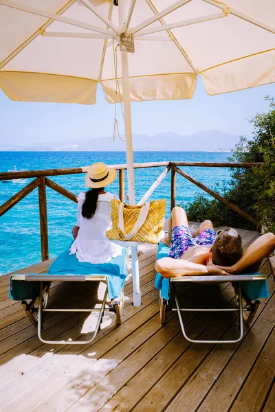 Paar in ligstoelen op een tropisch strand van Kreta Griekenland — Stockfoto