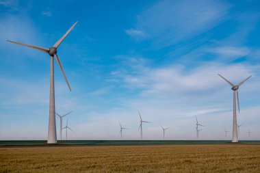 Fırtınalı bulutları, mavi gökyüzü, okyanusta yel değirmeni parkı olan açık deniz yel değirmeni parkı. Hollanda 