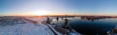 Zaanse Schans 'ın kış boyunca karla kaplı yel değirmeni köyü üzerindeki panoramik manzara, Zaanse Schans Hollanda' daki tarihi ahşap değirmenlerini rüzgâr değirmenlerine çevirdi