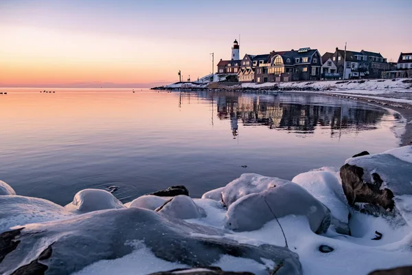 Winter in Urk met dijk en strand bij de vuurtoren van Urk sneeuw bedekt tijdens de winter, zonsondergang bij de vuurtoren van Urk Flevoland — Stockfoto