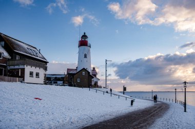 Kış boyunca Urk Hollanda deniz feneri karla kaplı kıyı şeridi, Hollanda 'da deniz feneri karlı kış havasında Urk manzarası