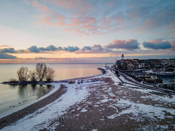 Urk Nederlandse vuurtoren tijdens de winter met besneeuwde kustlijn, Urk uitzicht op de vuurtoren besneeuwd landschap winterweer in Nederland — Stockfoto