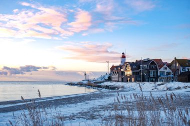 Kış boyunca Urk Hollanda deniz feneri karla kaplı kıyı şeridi, Hollanda 'da deniz feneri karlı kış havasında Urk manzarası