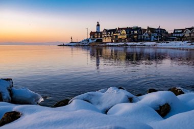 Kış boyunca Urk Hollanda deniz feneri karla kaplı kıyı şeridi, Hollanda 'da deniz feneri karlı kış havasında Urk manzarası