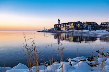 Kış boyunca Urk Hollanda deniz feneri karla kaplı kıyı şeridi, Hollanda 'da deniz feneri karlı kış havasında Urk manzarası