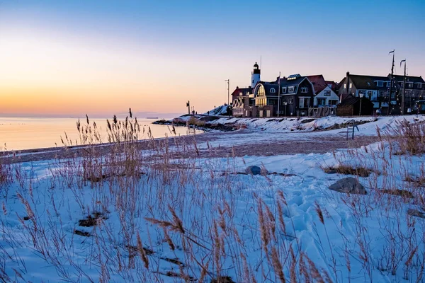 Urk Nederlandse vuurtoren tijdens de winter met besneeuwde kustlijn, Urk uitzicht op de vuurtoren besneeuwd landschap winterweer in Nederland — Stockfoto