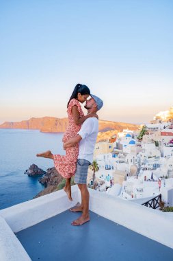 Santorini Yunanistan, orta yaşlı Avrupalı ve Asyalı genç çift Yunanistan 'ın Oia Santorini köyünde tatilde, Santorini' de lüks tatil