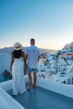 Santorini Yunanistan, orta yaşlı Avrupalı ve Asyalı genç çift Yunanistan 'ın Oia Santorini köyünde tatilde, Santorini' de lüks tatil