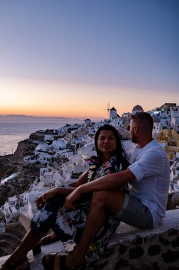 Santorini Yunanistan, orta yaşlı Avrupalı ve Asyalı genç çift Yunanistan 'ın Oia Santorini köyünde tatilde, Santorini' de lüks tatil