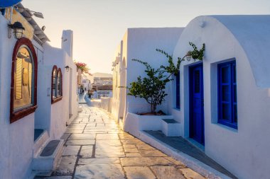 Oia köyü Santorini 'nin mavi kubbeleri ve beyaz boyalı evi günbatımında Santorini adasında Yunanistan' da
