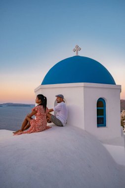 Santorini Yunanistan, orta yaşlı Avrupalı ve Asyalı genç çift Yunanistan 'ın Oia Santorini köyünde tatilde, Santorini' de lüks tatil