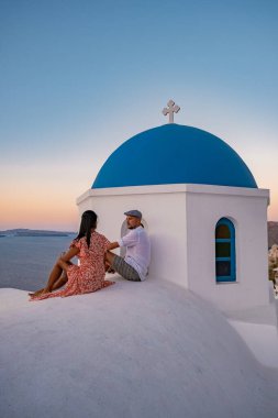 Santorini Yunanistan, orta yaşlı Avrupalı ve Asyalı genç çift Yunanistan 'ın Oia Santorini köyünde tatilde, Santorini' de lüks tatil