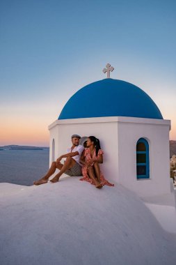 Santorini Yunanistan, orta yaşlı Avrupalı ve Asyalı genç çift Yunanistan 'ın Oia Santorini köyünde tatilde, Santorini' de lüks tatil