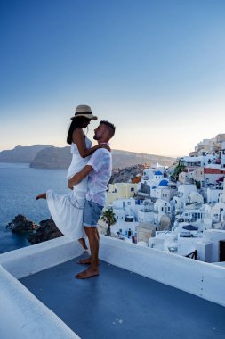 Santorini Yunanistan, orta yaşlı Avrupalı ve Asyalı genç çift Yunanistan 'ın Oia Santorini köyünde tatilde, Santorini' de lüks tatil