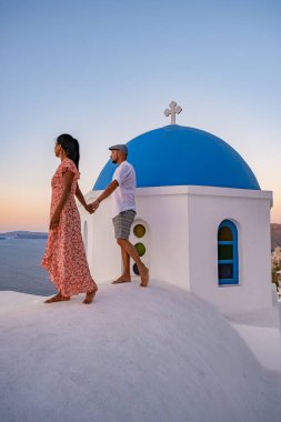 Santorini Yunanistan, orta yaşlı Avrupalı ve Asyalı genç çift Yunanistan 'ın Oia Santorini köyünde tatilde, Santorini' de lüks tatil