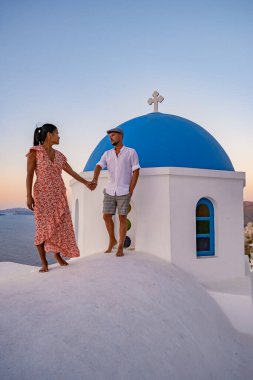 Santorini Yunanistan, orta yaşlı Avrupalı ve Asyalı genç çift Yunanistan 'ın Oia Santorini köyünde tatilde, Santorini' de lüks tatil