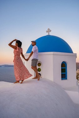 Santorini Yunanistan, orta yaşlı Avrupalı ve Asyalı genç çift Yunanistan 'ın Oia Santorini köyünde tatilde, Santorini' de lüks tatil