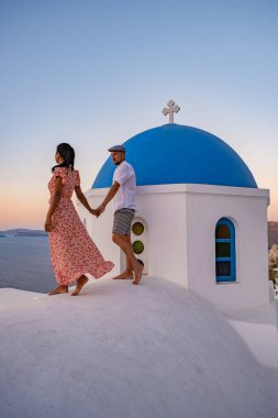 Santorini Yunanistan, orta yaşlı Avrupalı ve Asyalı genç çift Yunanistan 'ın Oia Santorini köyünde tatilde, Santorini' de lüks tatil