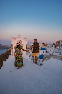 Santorini Yunanistan, orta yaşlı Avrupalı ve Asyalı genç çift Yunanistan 'ın Oia Santorini köyünde tatilde, Santorini' de lüks tatil