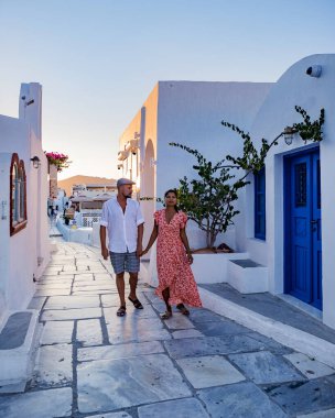 Santorini Yunanistan, orta yaşlı Avrupalı ve Asyalı genç çift Yunanistan 'ın Oia Santorini köyünde tatilde, Santorini' de lüks tatil