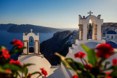 Oia köyü Santorini 'nin mavi kubbeleri ve beyaz boyalı evi günbatımında Santorini adasında Yunanistan' da