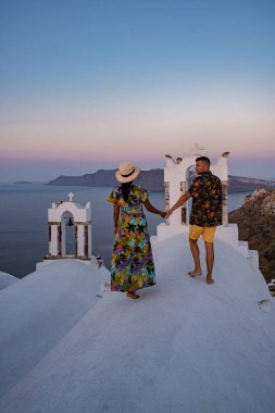 Santorini Yunanistan, orta yaşlı Avrupalı ve Asyalı genç çift Yunanistan 'ın Oia Santorini köyünde tatilde, Santorini' de lüks tatil