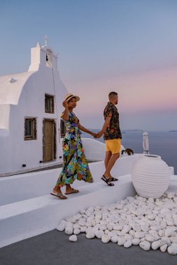 Santorini Yunanistan, orta yaşlı Avrupalı ve Asyalı genç çift Yunanistan 'ın Oia Santorini köyünde tatilde, Santorini' de lüks tatil