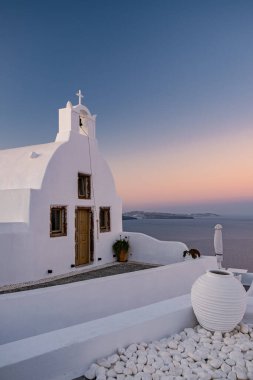 Oia köyü Santorini 'nin mavi kubbeleri ve beyaz boyalı evi günbatımında Santorini adasında Yunanistan' da