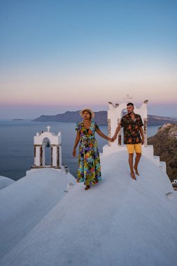 Santorini Yunanistan, orta yaşlı Avrupalı ve Asyalı genç çift Yunanistan 'ın Oia Santorini köyünde tatilde, Santorini' de lüks tatil