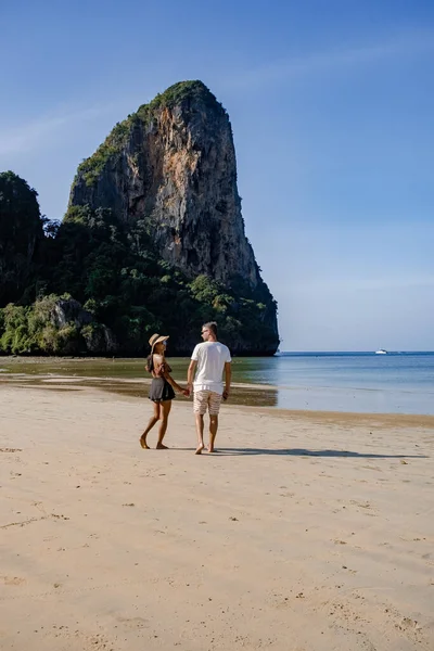 Couple mid age on tropical beach in Thailand, tourist walking on a white tropical beach, Railay beach with on the background lontail boat drop off tourist — Stock Photo, Image