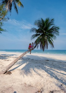 Tayland 'da tatil yapan çift, Chumpon eyaleti, palmiye ağaçlı beyaz tropikal plaj Tayland' da Wua Laen plajı Chumphon bölgesi, plajda asılı palmiye ağacı ve Tayland 'da tatilde olan çift.
