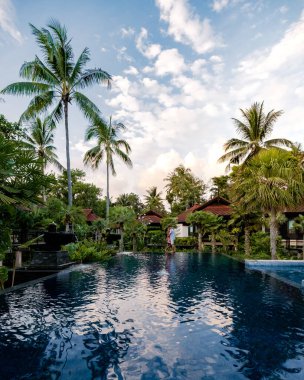 Asya 'da yüzme havuzunda orta yaşlı erkekler ve kadınlar, tatilde olan Avrupalı erkek ve Asyalı kadınlar