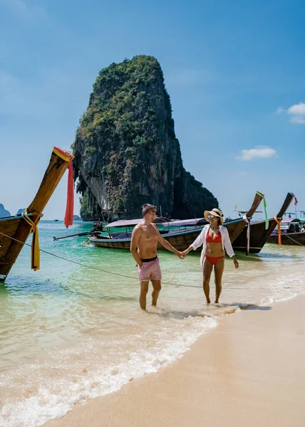 Couple mid age on tropical beach in Thailand, tourist walking on a white tropical beach, Railay beach with on the background lontail boat drop off tourist — Stock Photo, Image