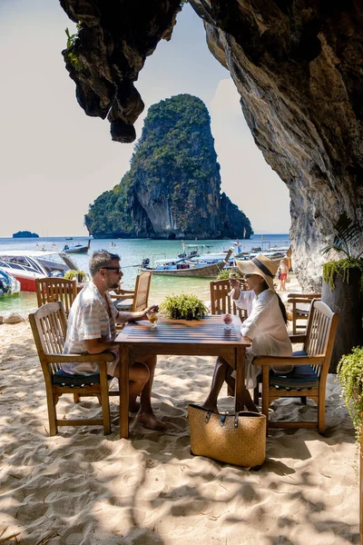 Couple mid age on tropical beach in Thailand, tourist walking on a white tropical beach, Railay beach with on the background lontail boat drop off tourist — Stock Photo, Image