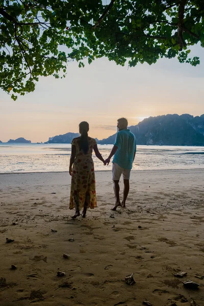 Par tittar på solnedgången på stranden, Eropean man och asiatisk kvinna solnedgången på stranden i Krabi Thailand — Stockfoto