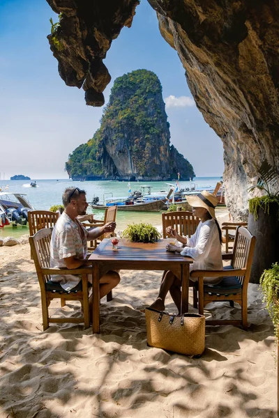 Couple mid age on tropical beach in Thailand, tourist walking on a white tropical beach, Railay beach with on the background lontail boat drop off tourist — Stock Photo, Image