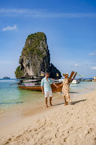 Couple mid age on tropical beach in Thailand, tourist walking on a white tropical beach, Railay beach with on the background lontail boat drop off tourist — Stock Photo, Image