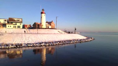 Kış boyunca Urk Hollanda deniz feneri karla kaplı kıyı şeridi, Hollanda 'da deniz feneri karlı kış havasında Urk manzarası